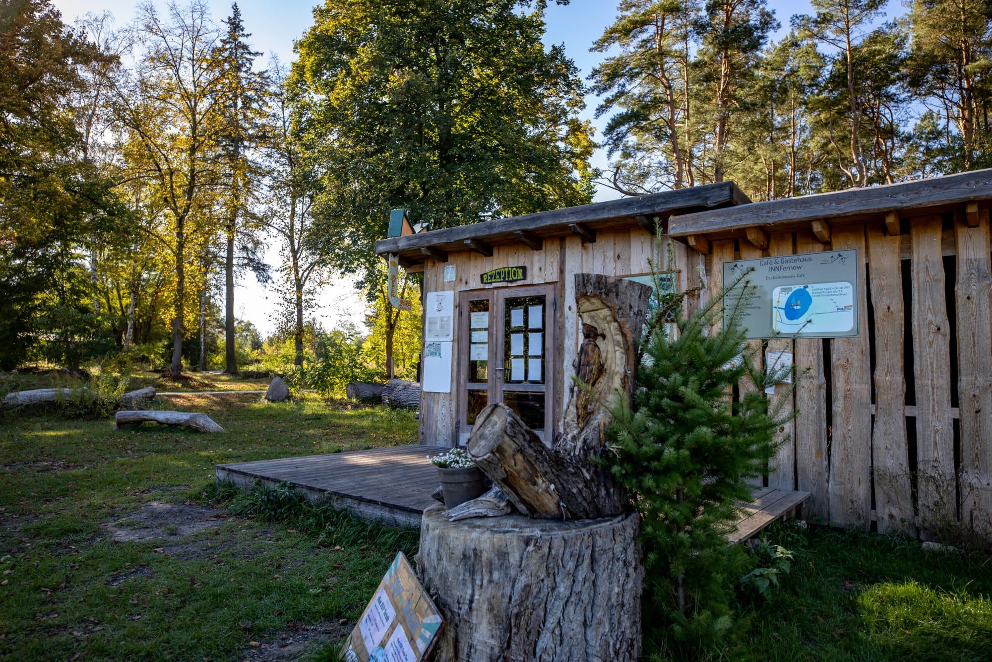 Die Rezeption aus Holz, davor ein Baumstamm mit Schildern